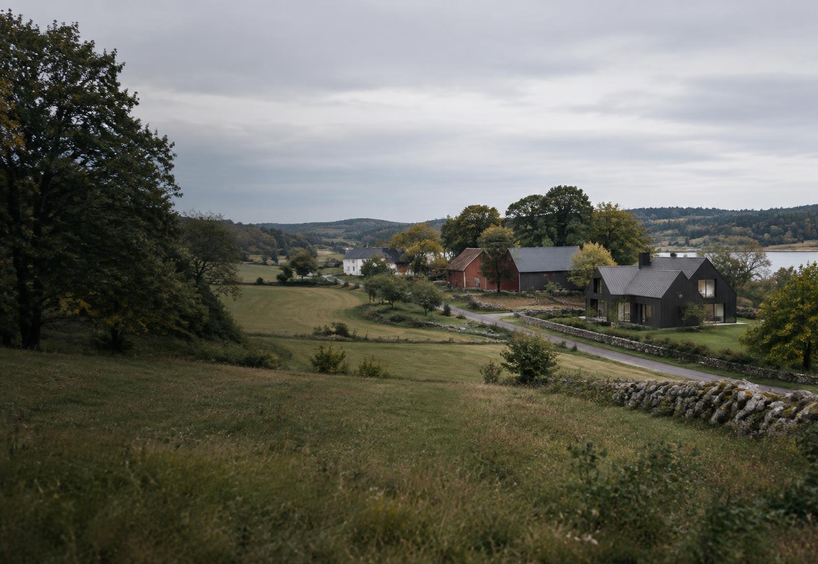 Svensk landsbygd med gårdar, bostäder, väg och omgivande mark